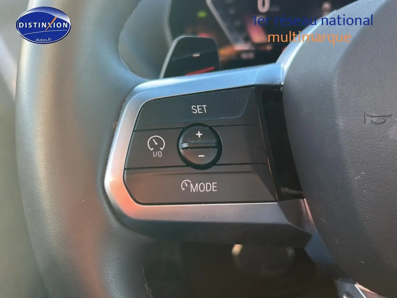 Gros plan sur les commandes de régulateur de vitesse au volant d’une BMW Série 1 blanche Alpine (f40) 118da 2025.