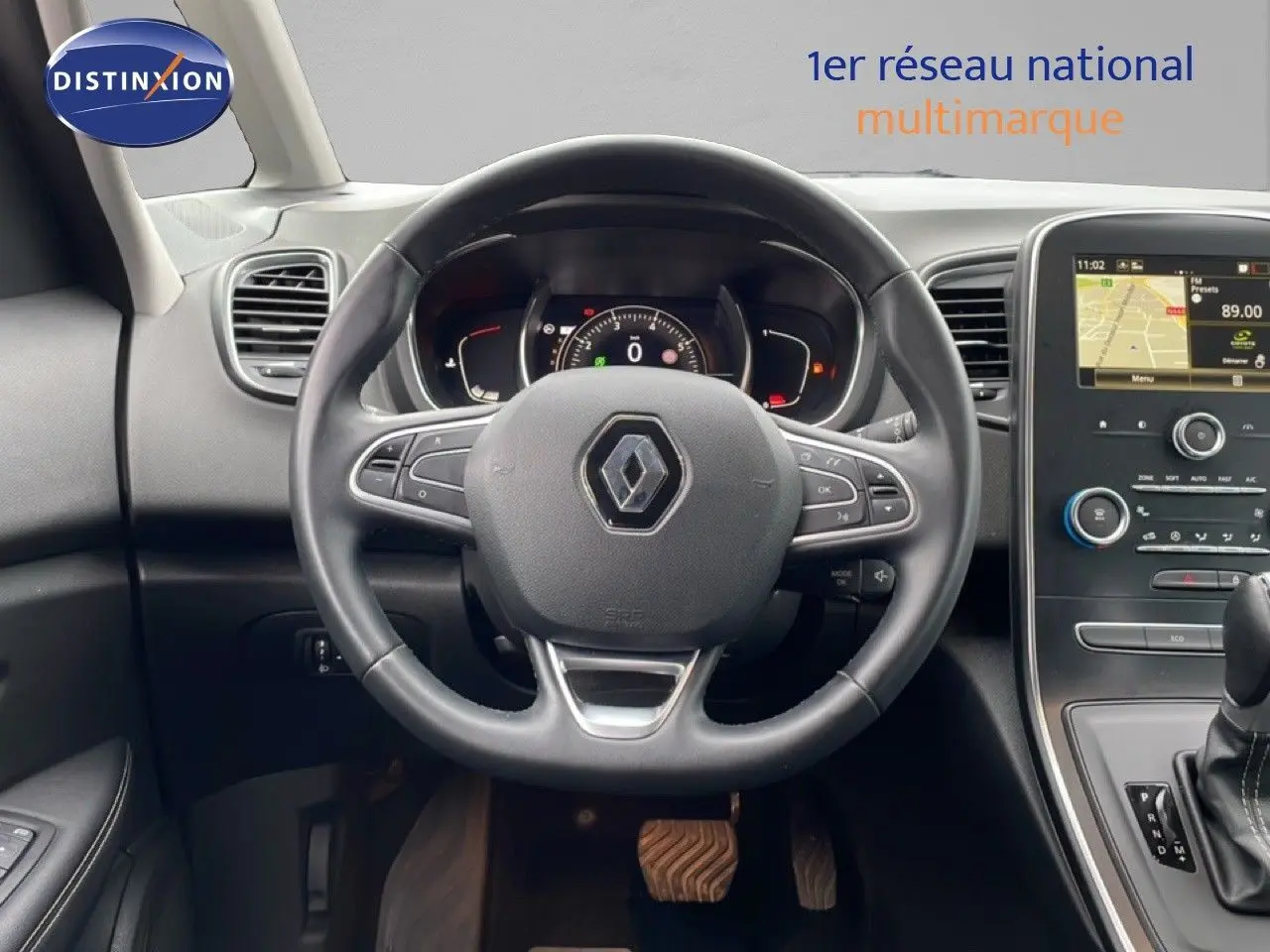 Vue intérieure centrée sur le volant noir cuir du Renault Grand Scénic 2022 avec tableau de bord et écran tactile.