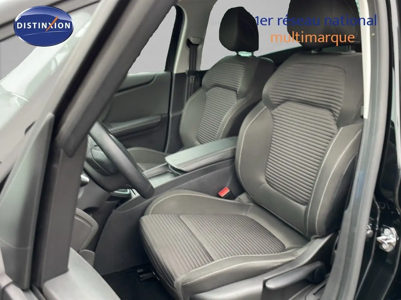 Vue intérieure côté conducteur du Renault Grand Scenic noir étoile métal, sièges tissu et cuir avec surpiqûres blanches.