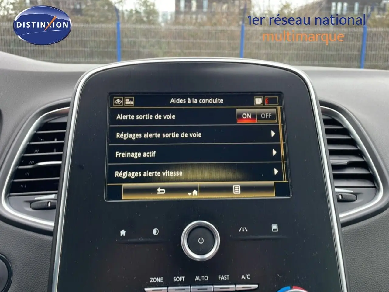 Vue intérieure centrée sur l’écran tactile du Renault Grand Scenic noir étoile métal, affichant les aides à la conduite.