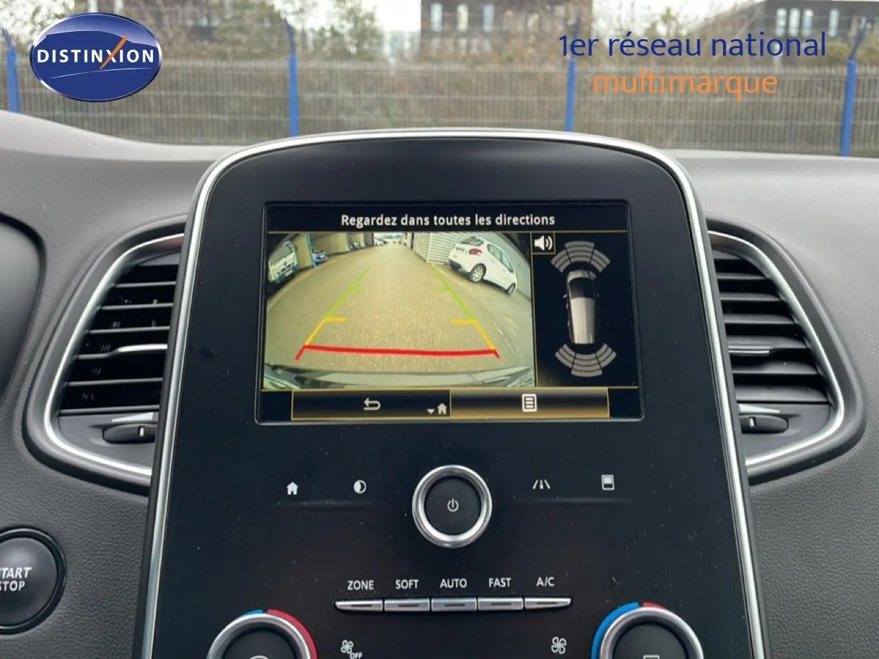 Vue intérieure du tableau de bord du Renault Grand Scenic noir étoile métal, avec écran de caméra de recul allumé.