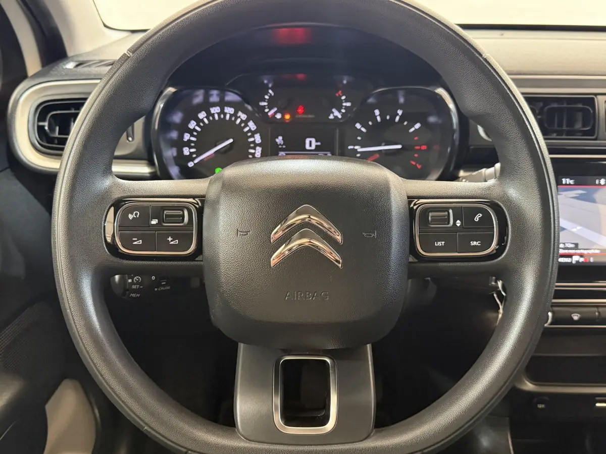 Vue rapprochée du volant multifonctions noir de la Citroën C3 2021 avec tableau de bord et écran tactile visibles.