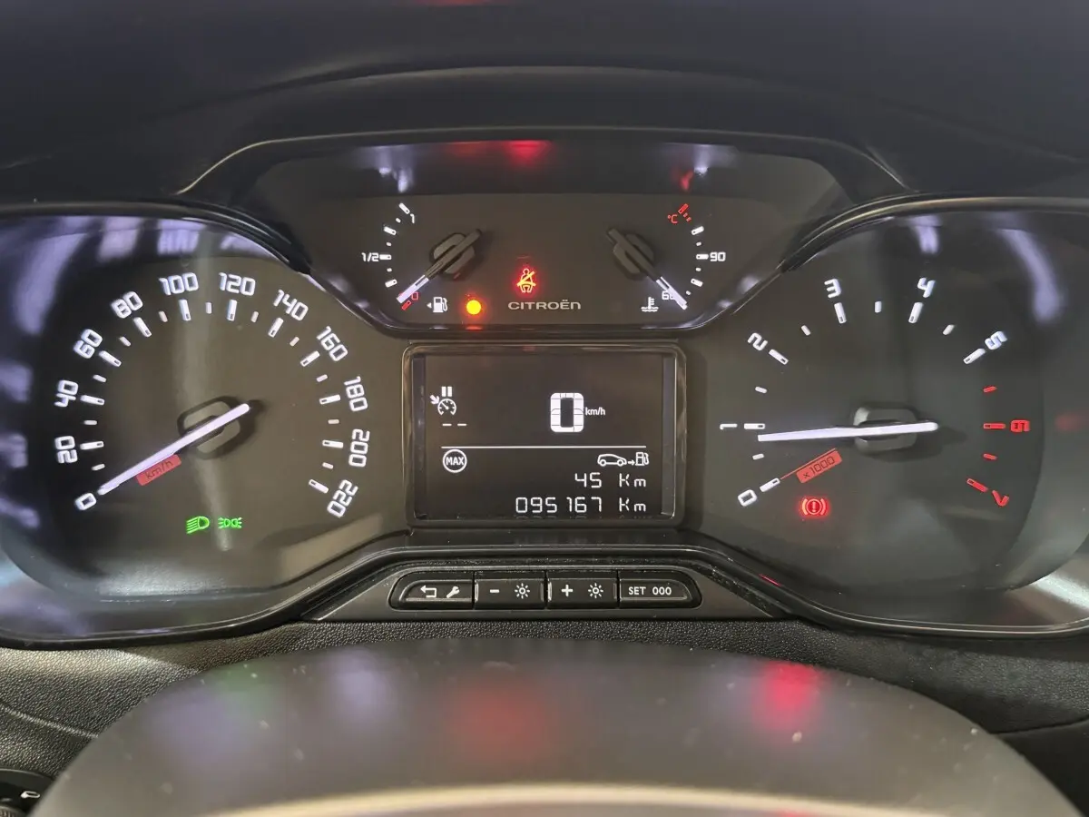 Vue rapprochée du tableau de bord numérique de la Citroën C3 blanc, affichant vitesse, compte-tours et jauges.