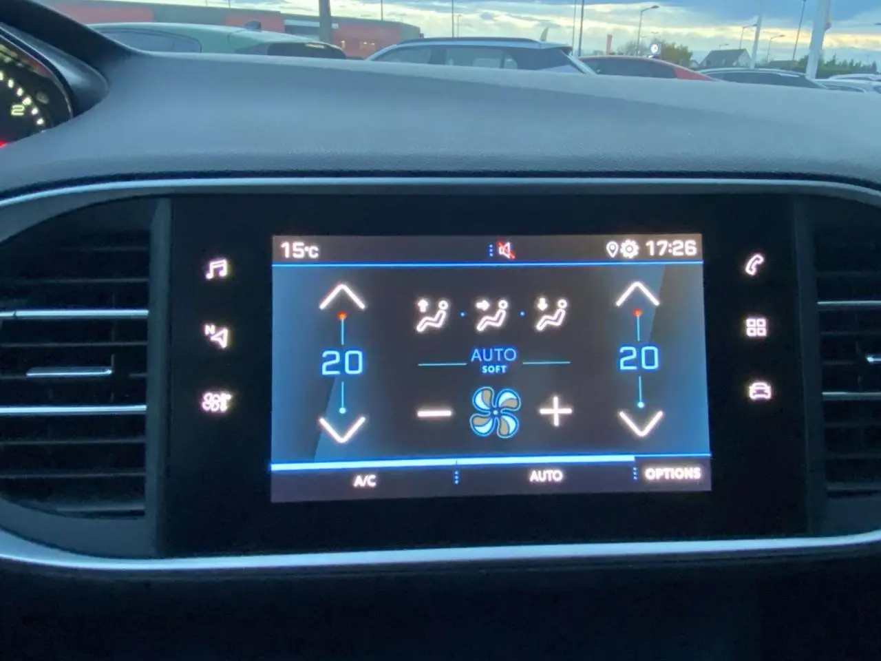 Écran tactile central affichant la climatisation automatique bi-zone dans une Peugeot 308 gris clair, vue intérieure frontale.