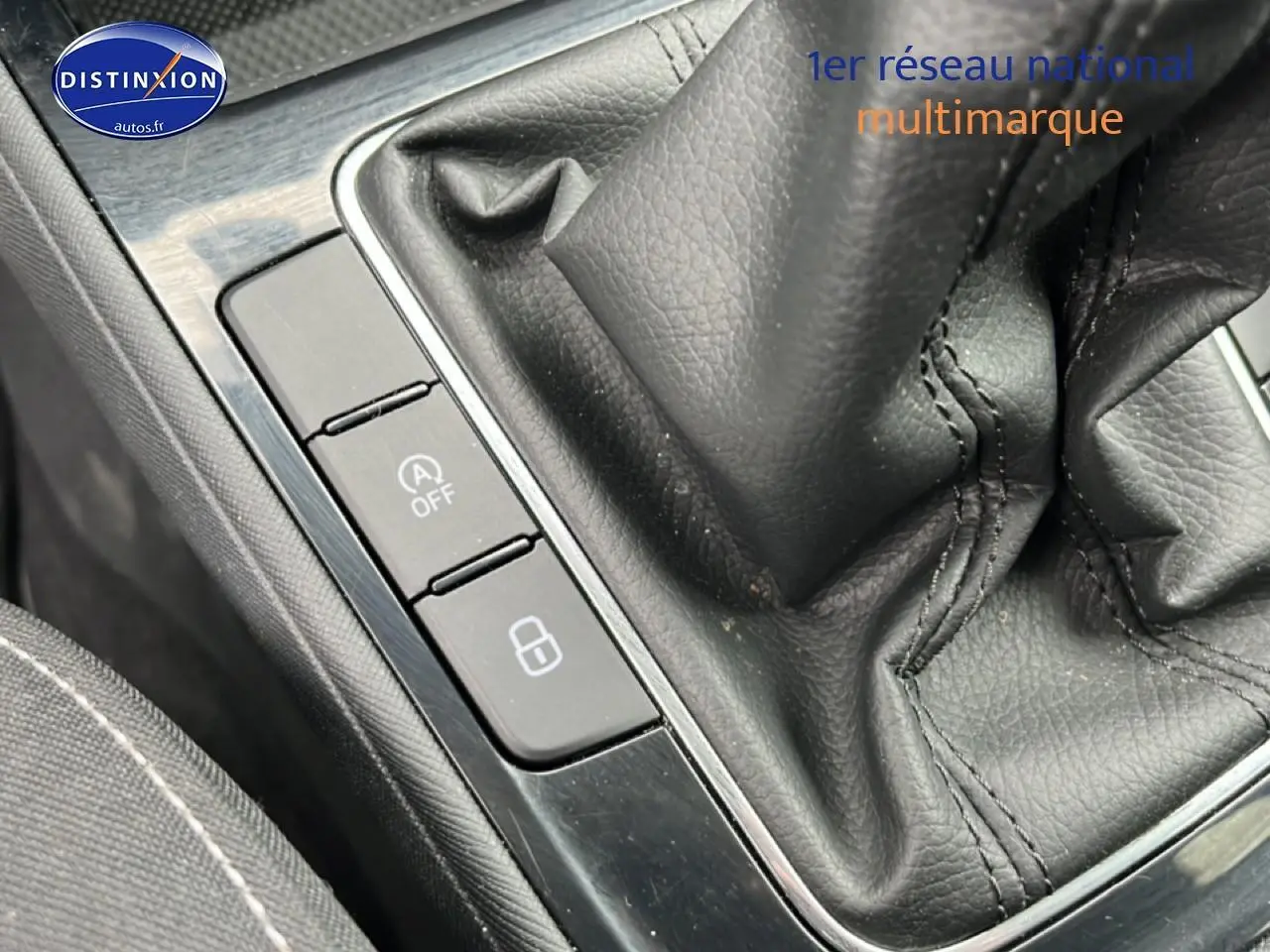 Gros plan sur la console centrale noire avec levier de vitesse cuir et boutons de commande sur une Skoda Fabia blanche.
