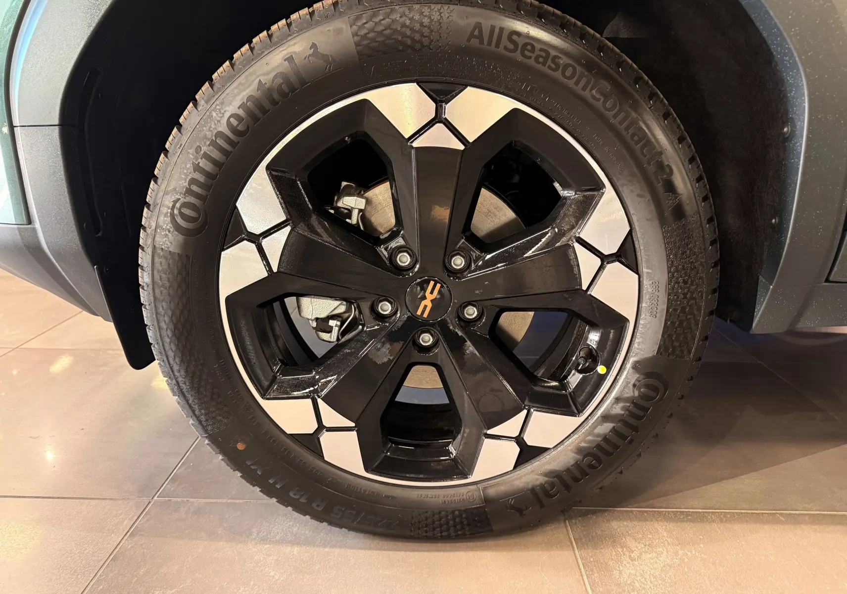 Gros plan sur la roue avant droite du Dacia Bigster Hybrid-G 150 4x4 en Vert Cèdre, avec jante noire et argentée distinctive.