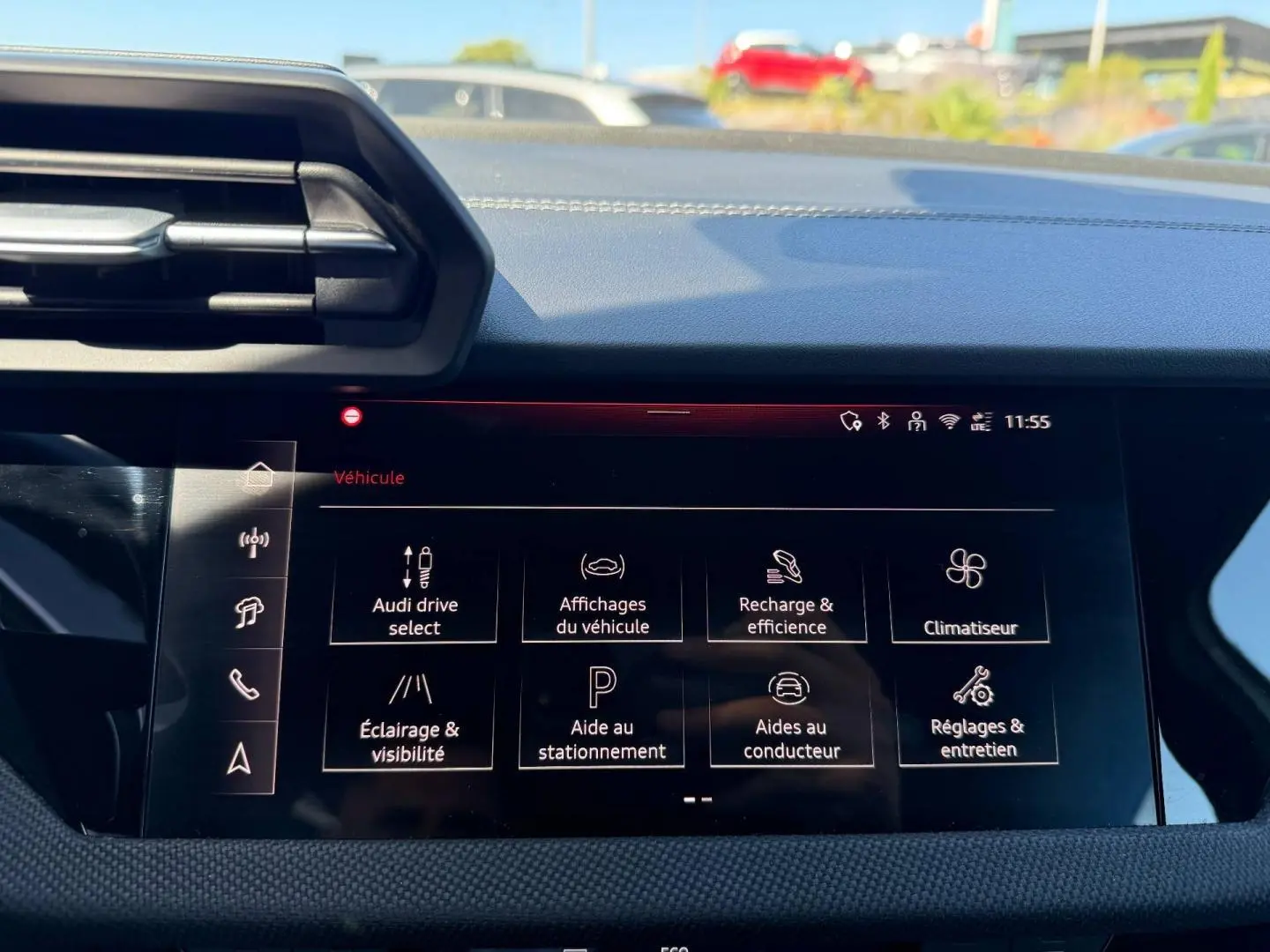Vue rapprochée de l’écran tactile central de l’Audi A3 Sportback 40 TFSI e 2025 affichant les options de conduite et climatisation.