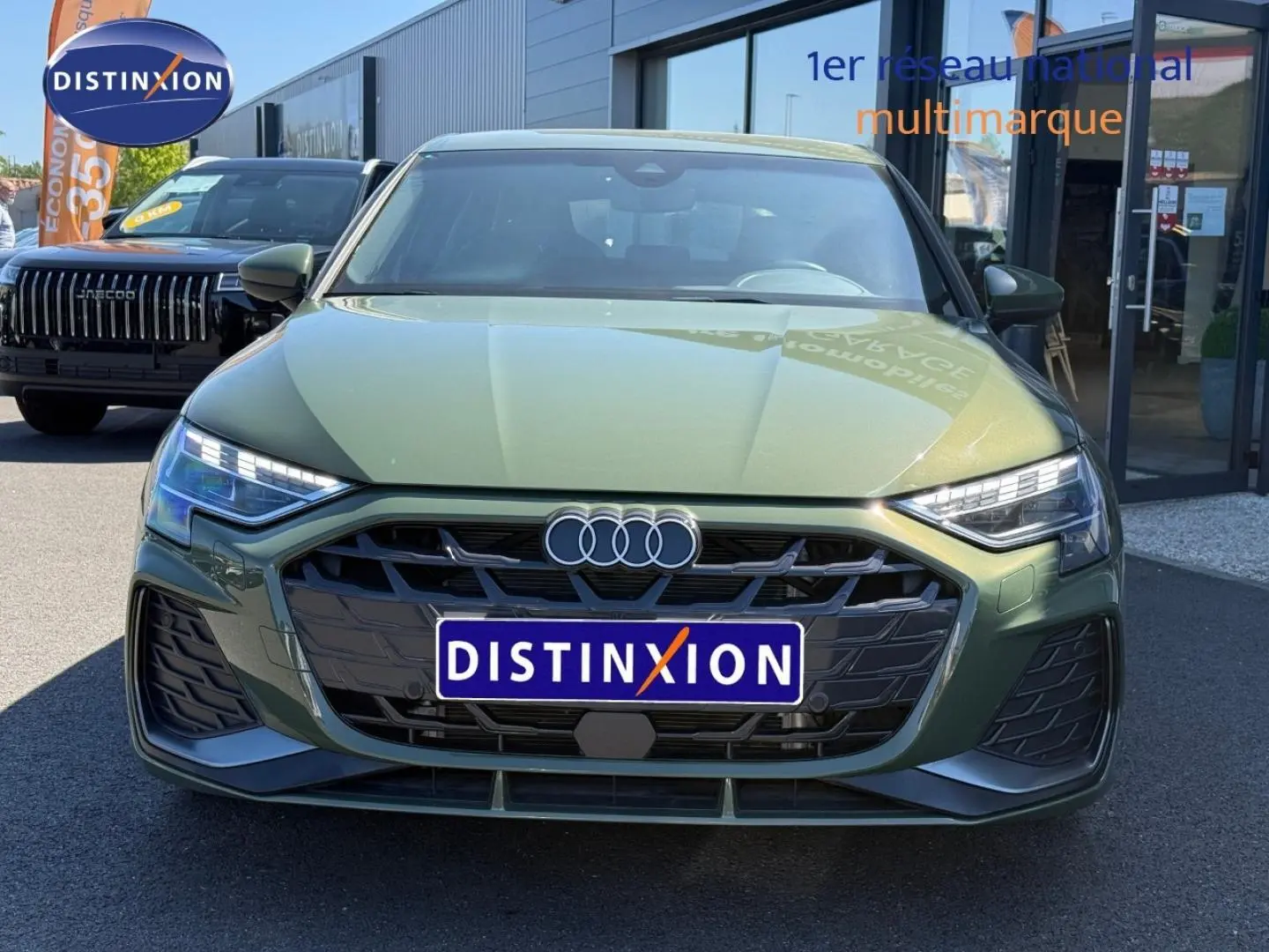 Vue de face d'une Audi A3 Sportback 40 TFSI e 204ch hybride en vert District métallisé avec calandre noire distinctive.