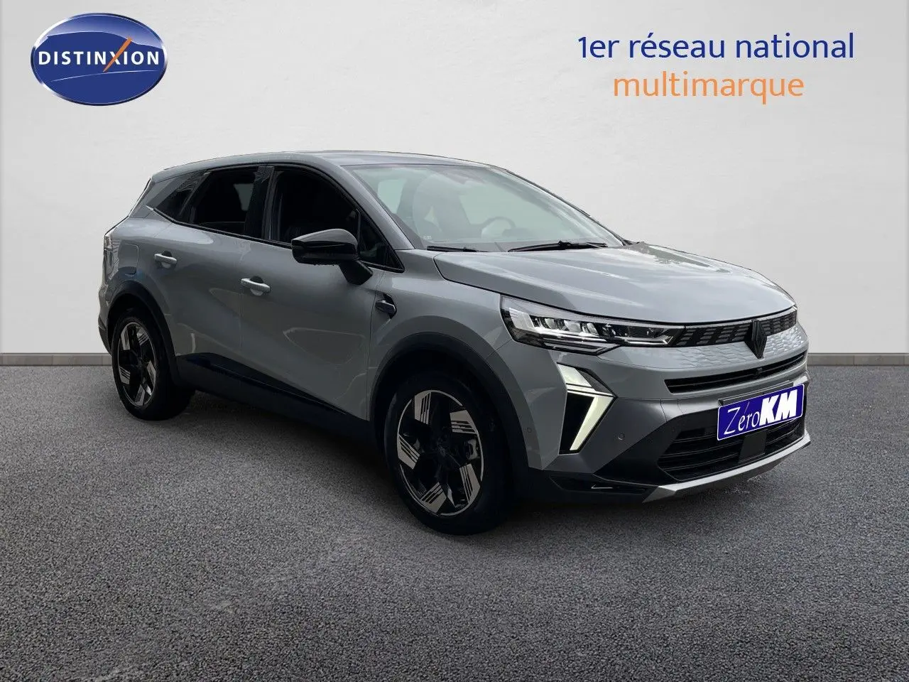 Renault Symbioz gris Rafale métal en 3/4 avant droit, SUV hybride avec feux LED distinctifs et jantes noires.