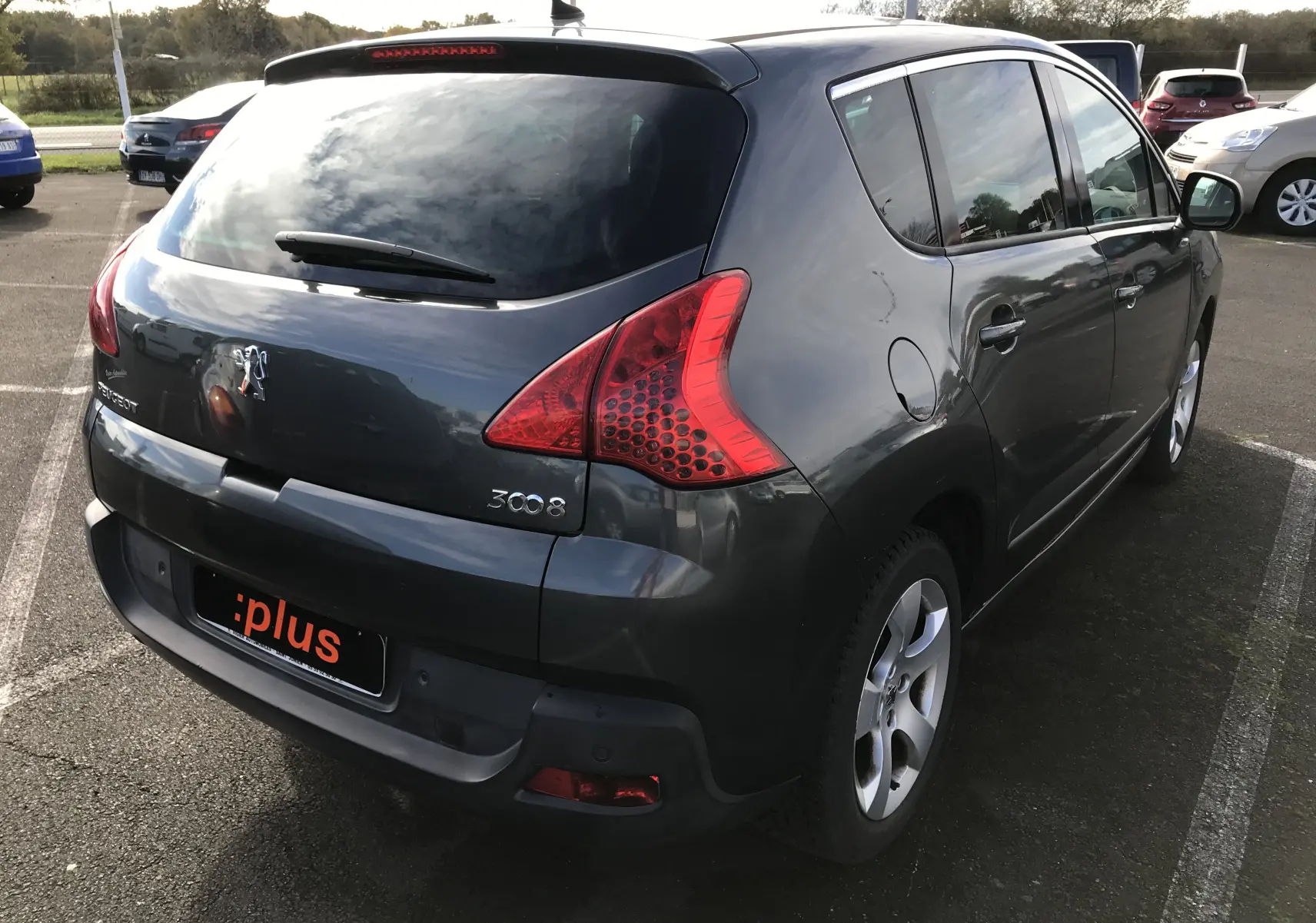 Vue 3/4 arrière droit d'un Peugeot 3008 gris anthracite de 2011 avec feux arrière caractéristiques et jantes alliage.