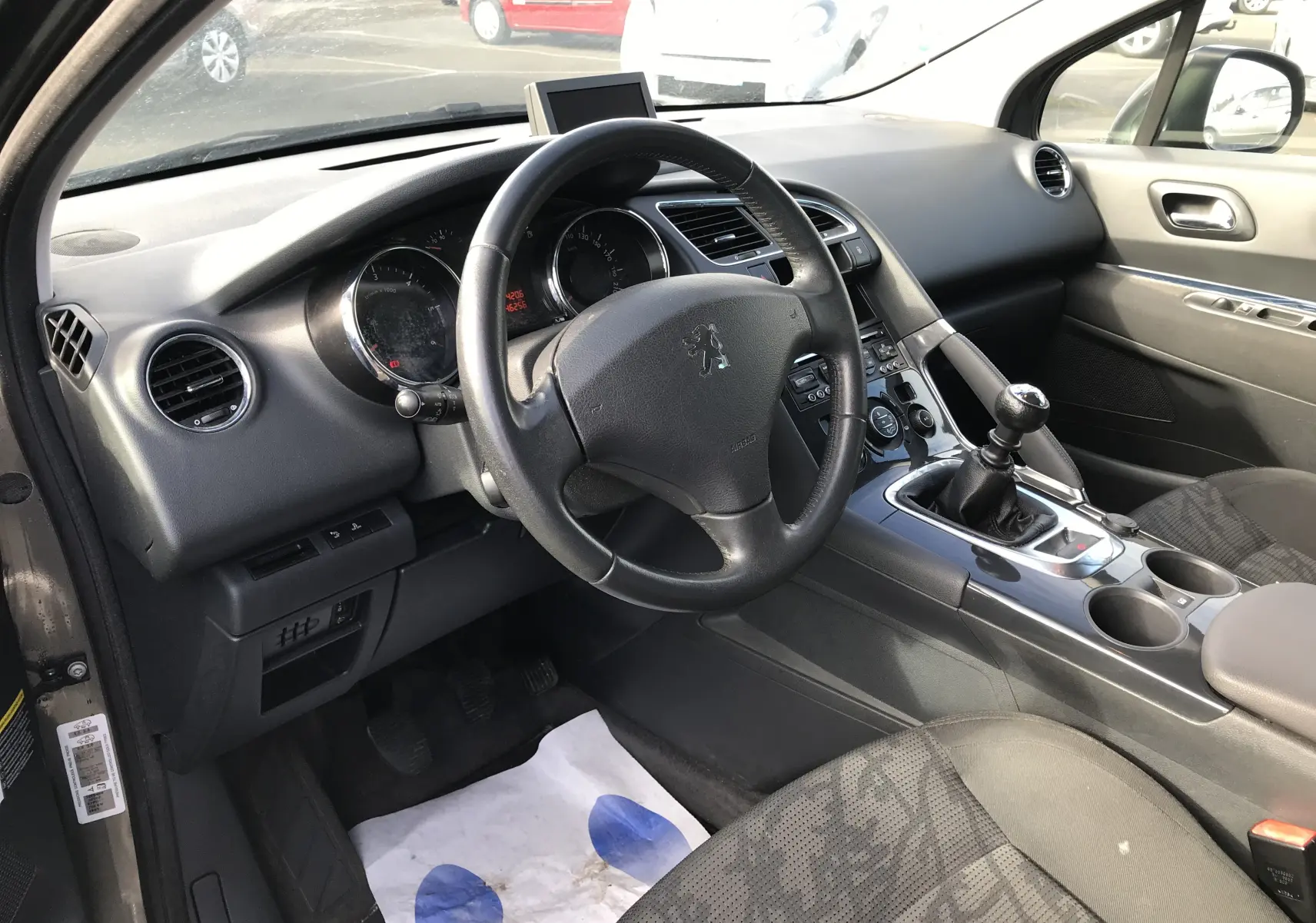 Intérieur côté conducteur du Peugeot 3008 gris anthracite de 2011 avec volant multifonction et boîte manuelle visible.