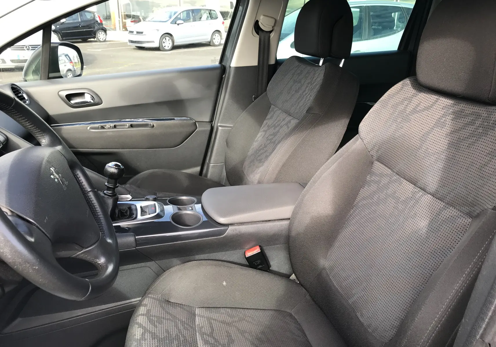 Intérieur avant droit du Peugeot 3008 gris anthracite de 2011, sièges tissu et levier de vitesse manuel visibles.