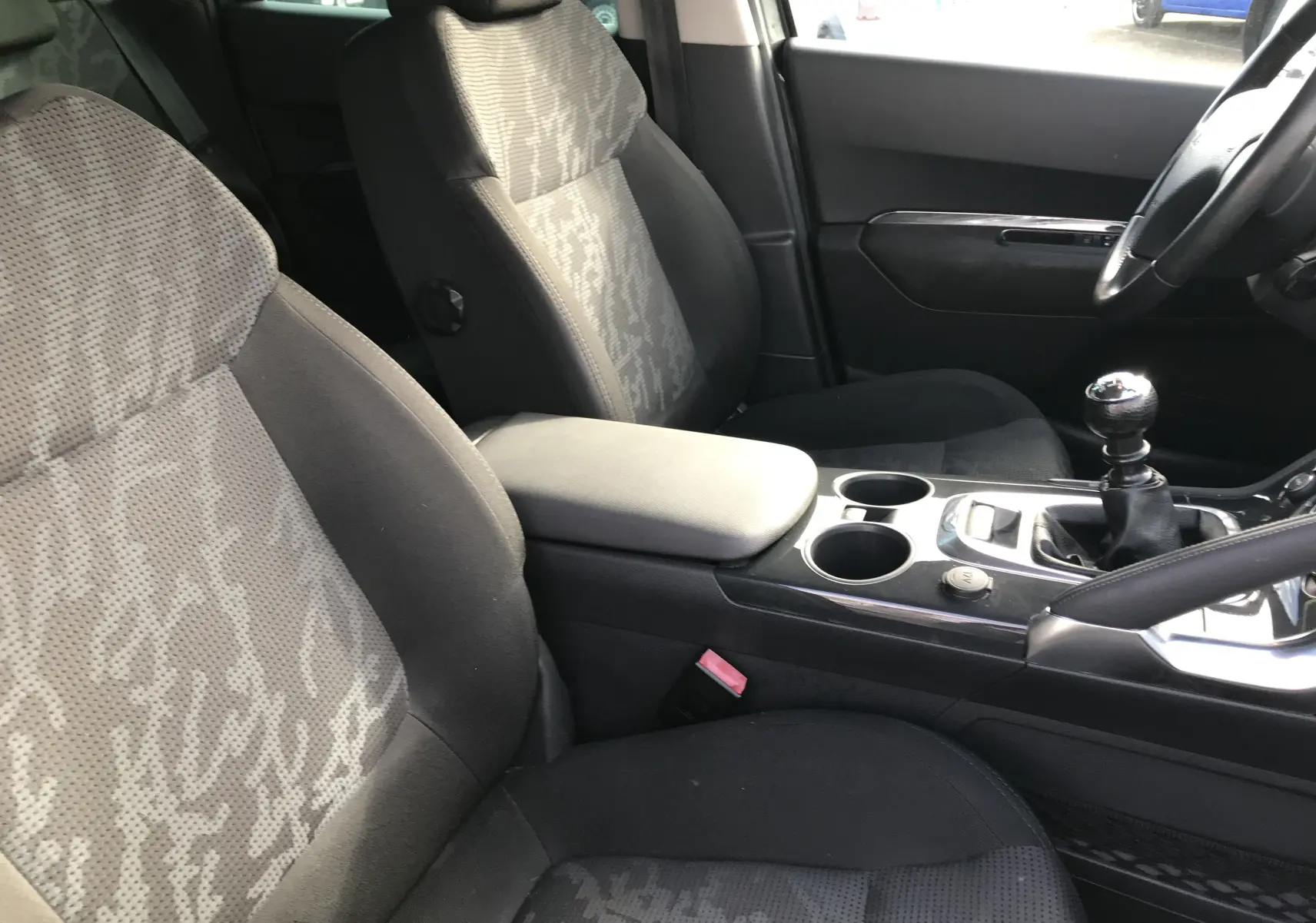 Vue intérieure côté conducteur du Peugeot 3008 gris anthracite de 2011, avec sièges tissu et levier de vitesses manuel.