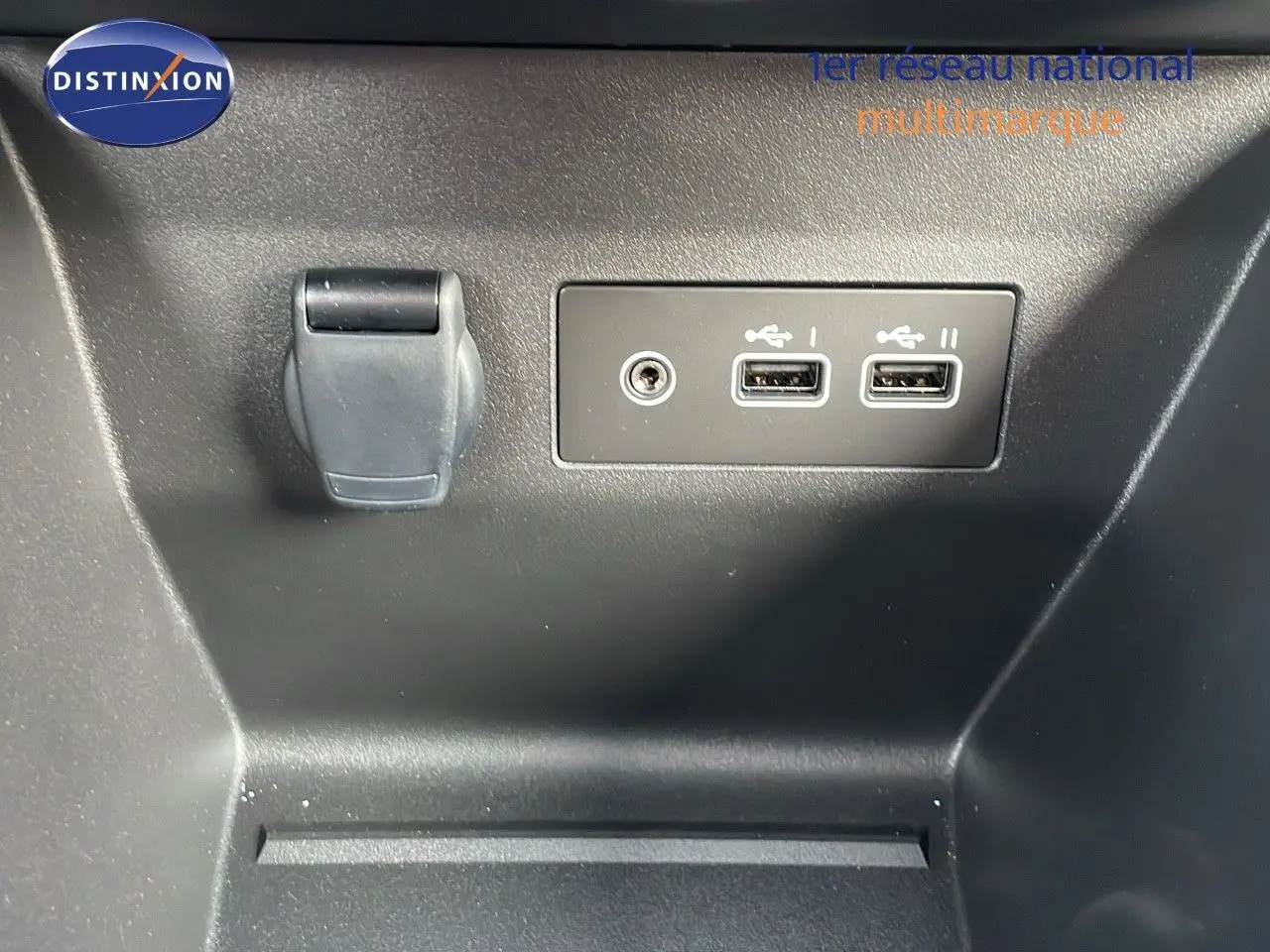 Prise USB double et prise jack intégrées dans la console centrale d'une Renault Clio noire étoile métal.