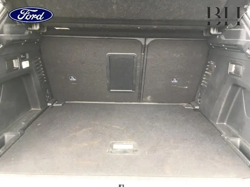 Coffre vide en vue intérieure arrière d'un Peugeot 3008 Rouge Ultimate avec trappe à skis centrale.