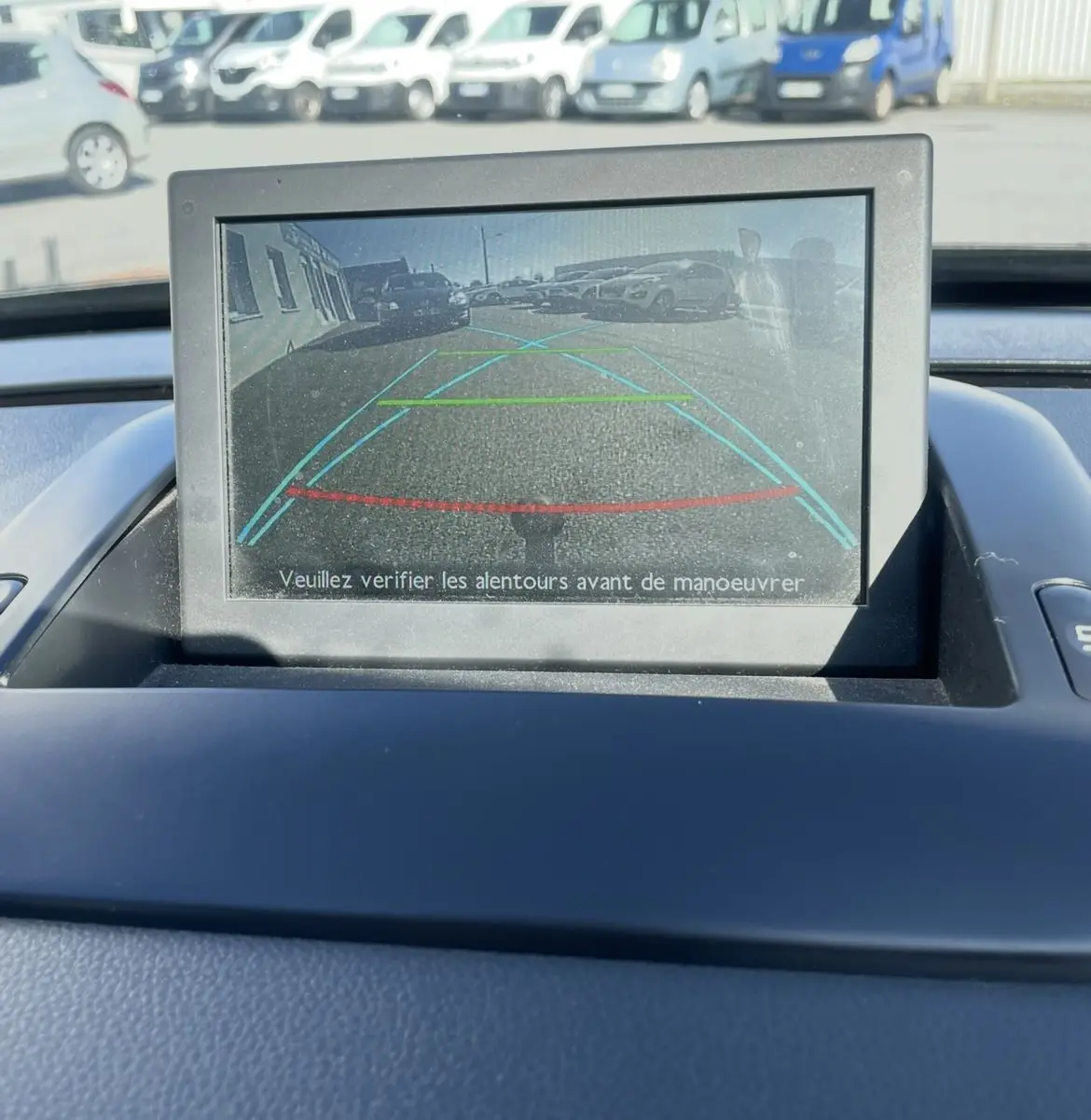 Écran de caméra de recul du Peugeot 3008 noir, affichant les lignes d’aide au stationnement arrière en extérieur.