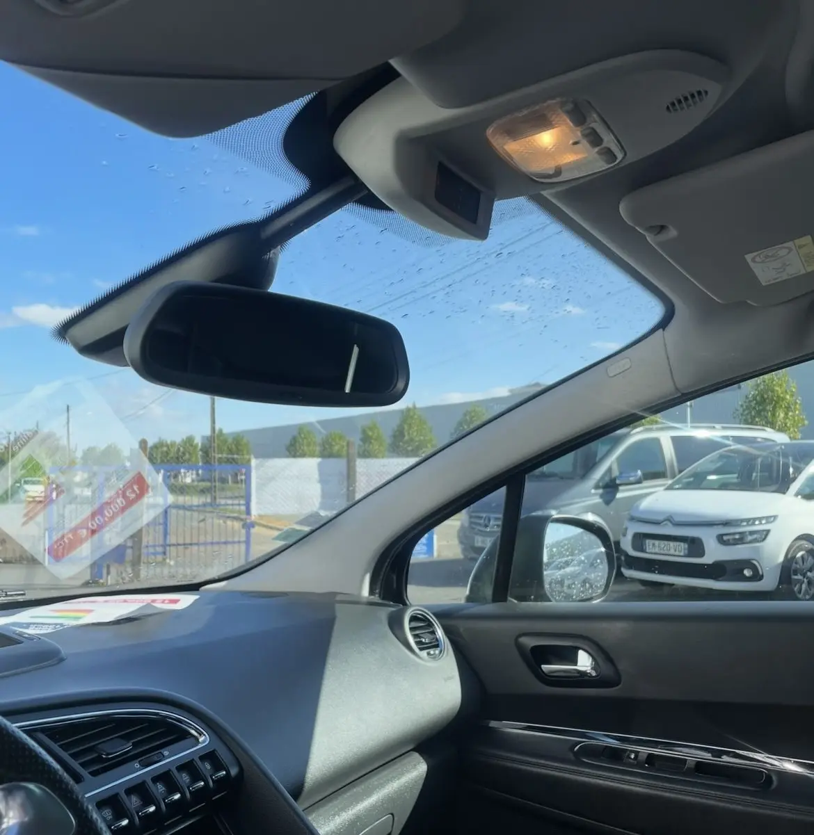 Vue intérieure côté passager avant du Peugeot 3008 noir, avec tableau de bord et rétroviseur central visibles.