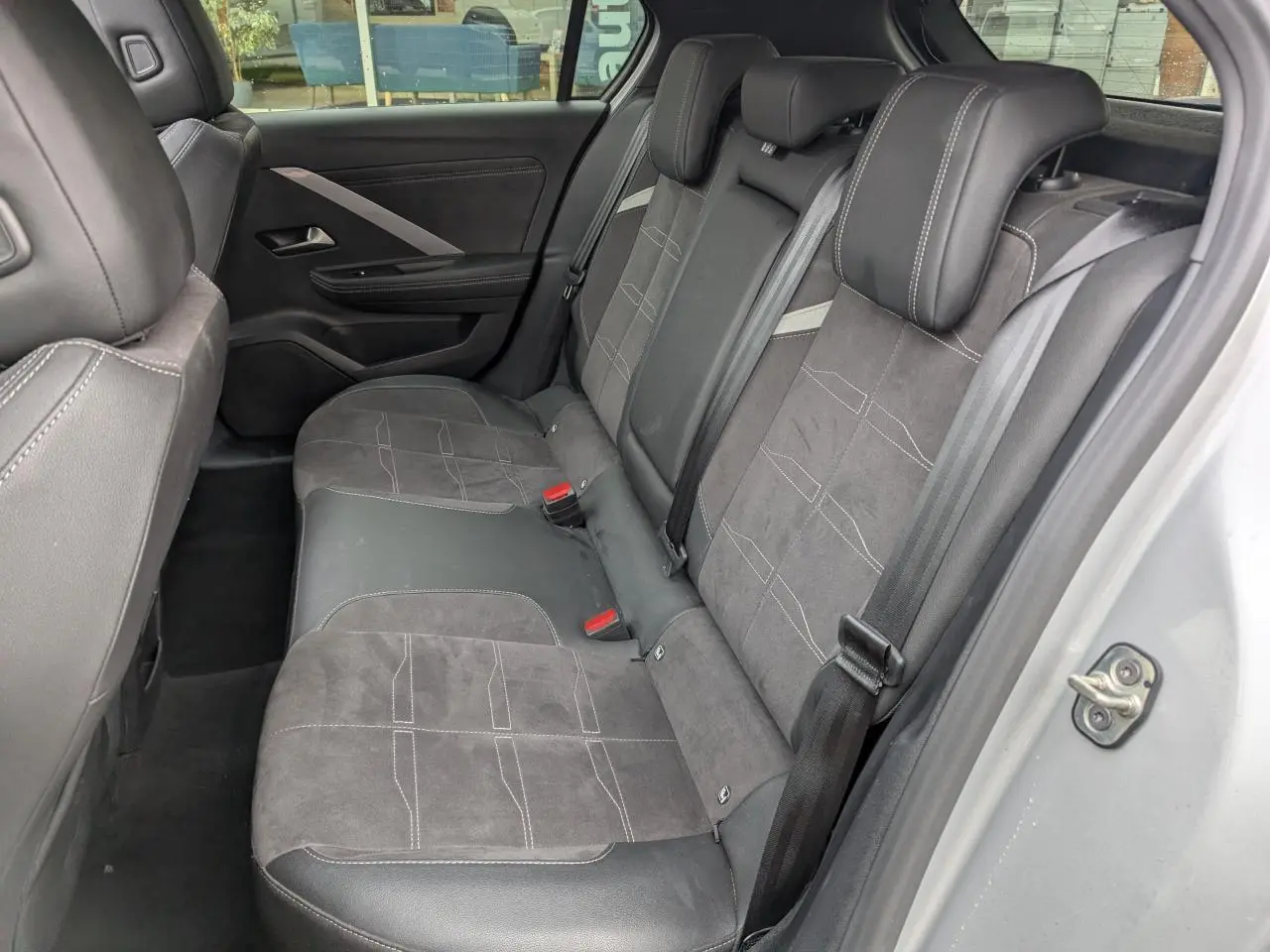 Vue côté gauche de la banquette arrière en sellerie mixte Alcantara et cuir noir de l'Opel Astra gris métallisé 2024.