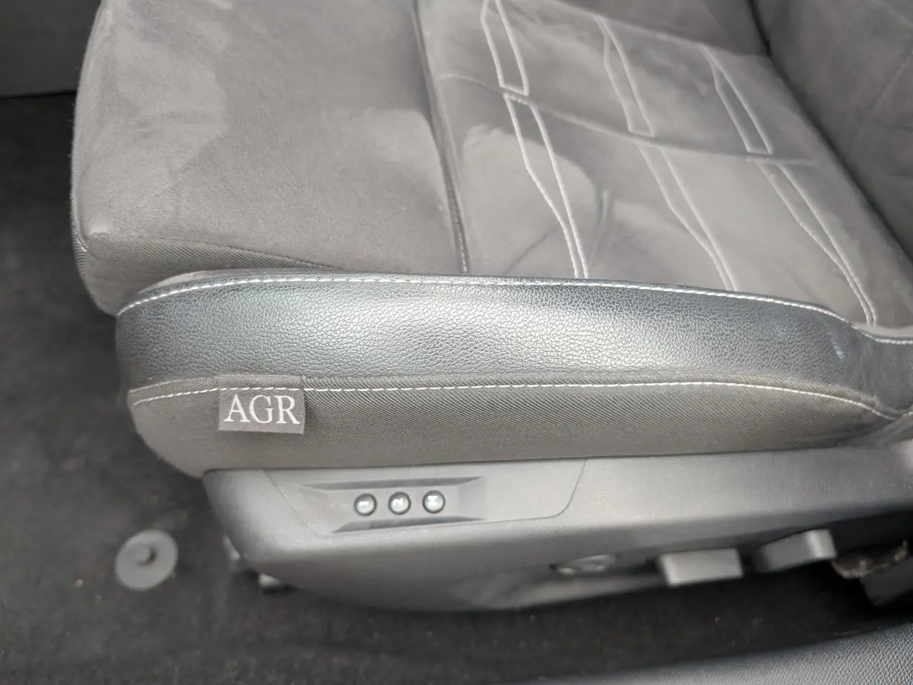 Gros plan sur le siège conducteur gris mixte Alcantara et cuir de l'Opel Astra 2024 avec label AGR et commandes électriques.