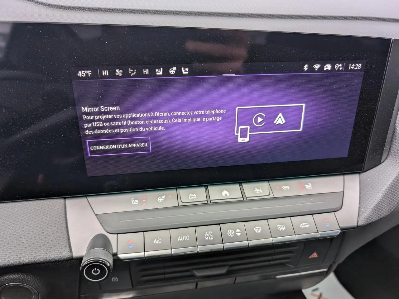 Vue rapprochée de la console centrale de l'Opel Astra 2024 avec écran tactile et commandes de climatisation.