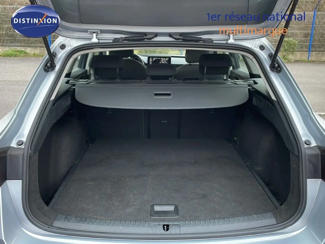Coffre ouvert vu de l'arrière d'une SEAT LEON ST gris urbain métal, montrant un espace de chargement spacieux et propre.