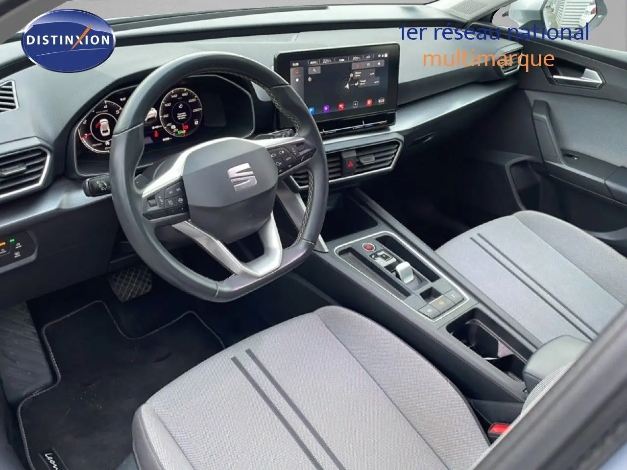 Intérieur de la SEAT LEON ST 2022 vu côté conducteur, avec tableau de bord numérique et sièges tissu gris clair.