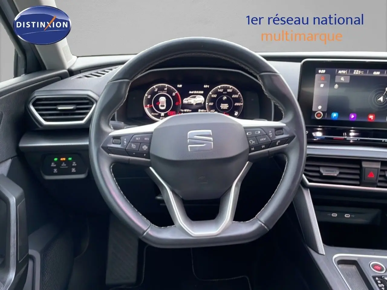 Intérieur du SEAT LEON ST 2022, vue centrée sur le volant cuir et tableau de bord numérique avec écran tactile.