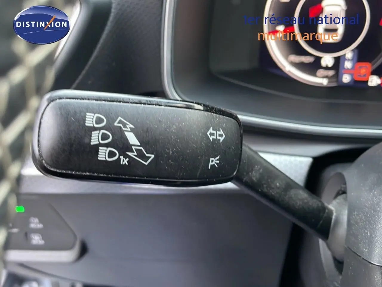 Gros plan sur la commande de clignotants et feux du tableau de bord d'une SEAT LEON ST gris urbain.