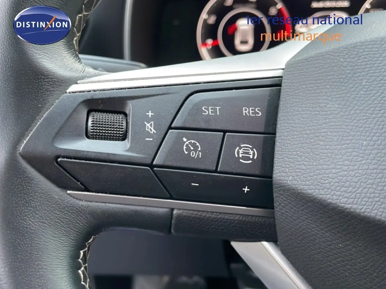 Gros plan sur les commandes de régulateur de vitesse au volant de la SEAT LEON ST 2.0 TDI 2022, intérieur noir.