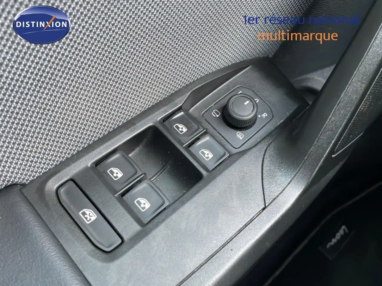 Gros plan sur les commandes de lève-vitres et rétroviseurs côté conducteur d'une SEAT LEON ST gris urbain 2022.