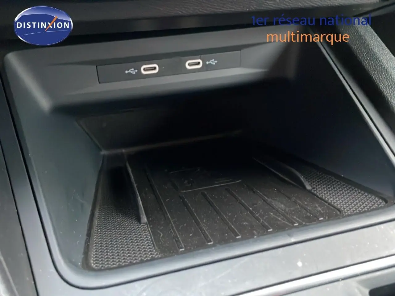 Gros plan sur le compartiment de rangement central avec ports USB-C dans une SEAT LEON ST gris urbain metal, vue intérieure.