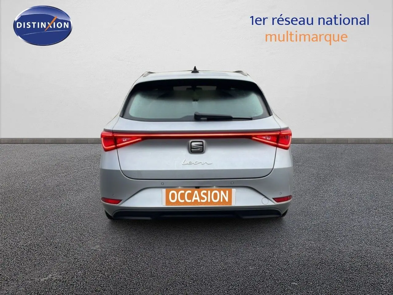 Vue arrière d'une SEAT Leon ST 2022 gris urbain métal avec feu arrière continu et plaque d'immatriculation "OCCASION".