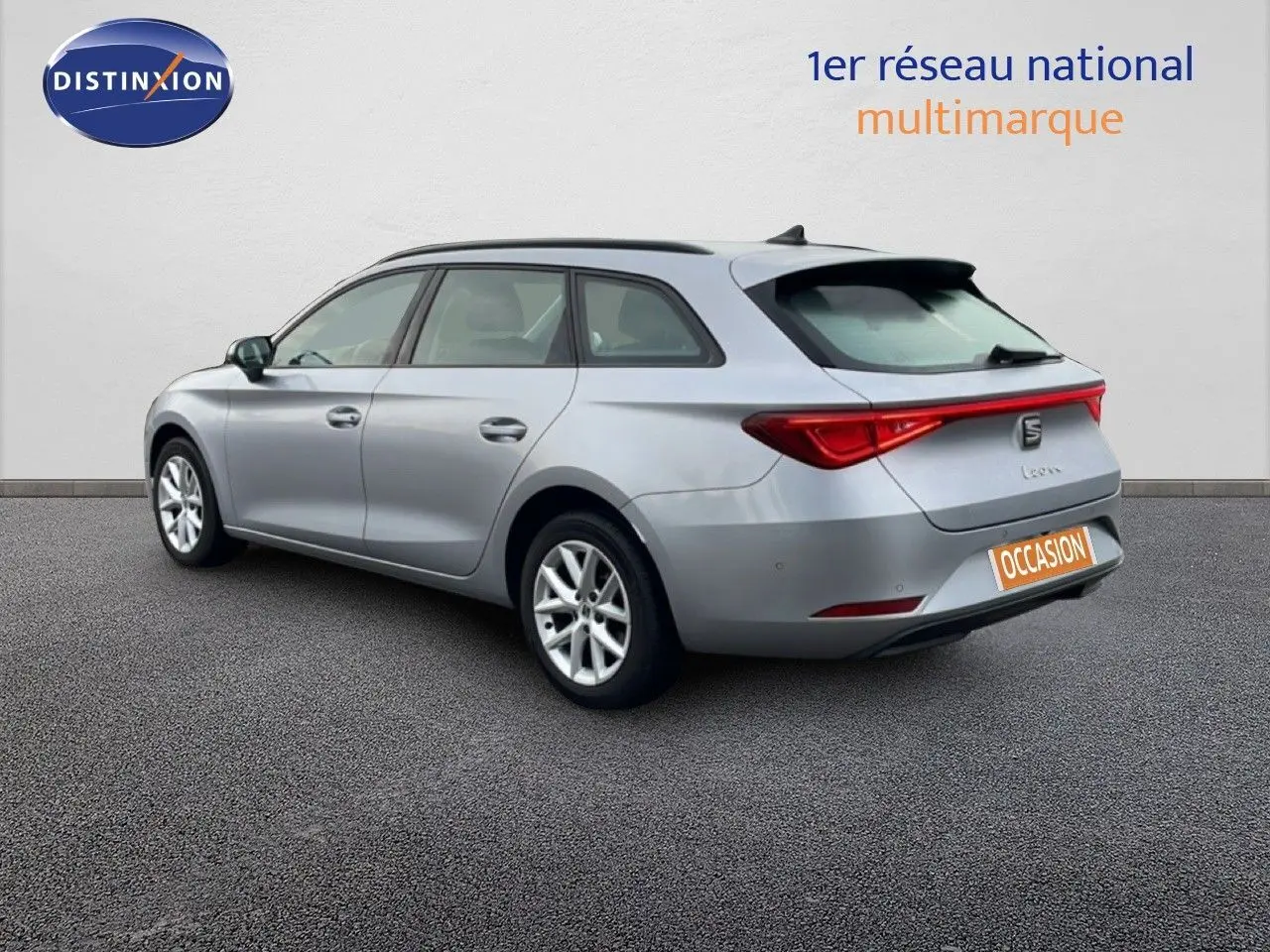 Vue 3/4 arrière droite d'une SEAT Leon ST gris urbain métal avec feux arrière allongés et toit panoramique.