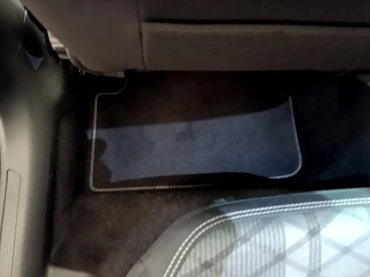 Détail du tapis de sol noir sous le siège arrière d'un Volkswagen Taigo 1.5 TSI 150 DSG R-Line 2023.