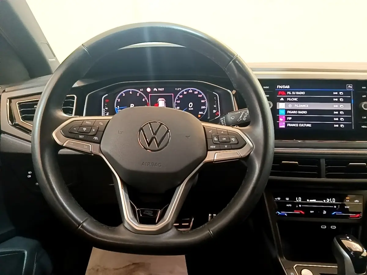 Vue intérieure centrée sur le volant cuir noir et le tableau de bord digital du Volkswagen Taigo 1.5 TSI R-Line 2023.