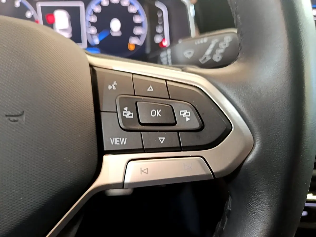 Gros plan sur les commandes gauche du volant cuir noir du Volkswagen Taigo 1.5 TSI 150 DSG R-Line 2023.