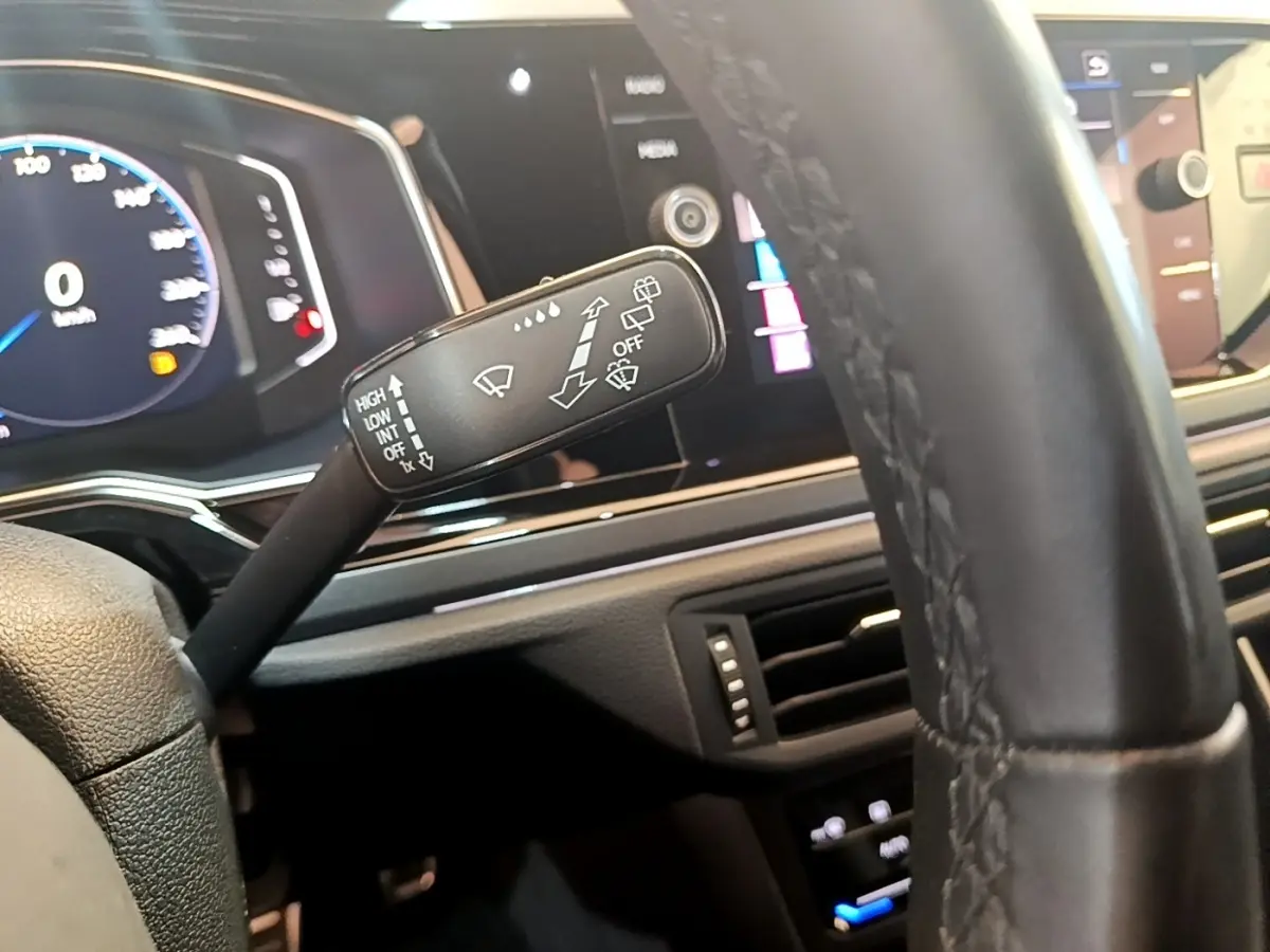 Gros plan sur la manette d’essuie-glace côté gauche du tableau de bord du Volkswagen Taigo noir 2023.