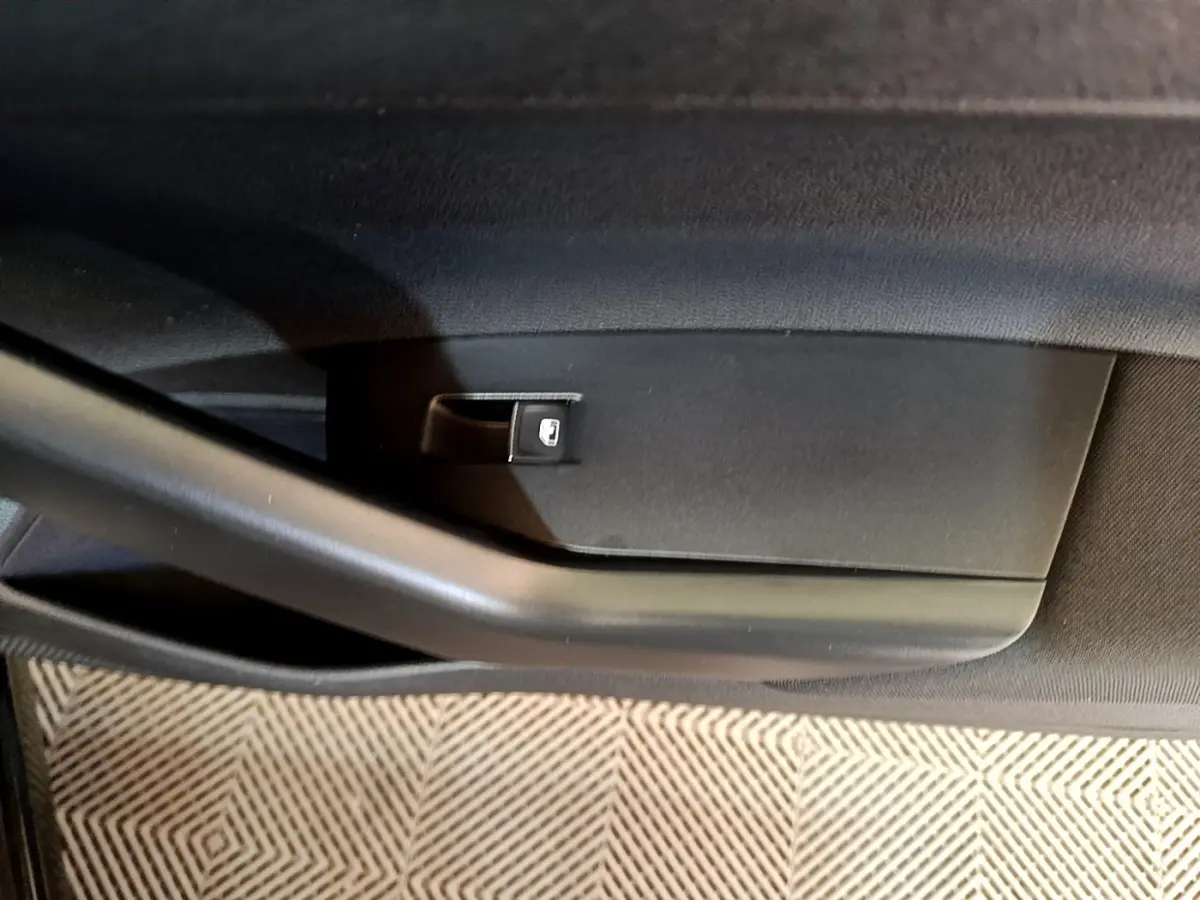 Gros plan sur la commande de lève-vitre côté gauche de la porte intérieure noire du Volkswagen Taigo 1.5 TSI R-Line 2023.