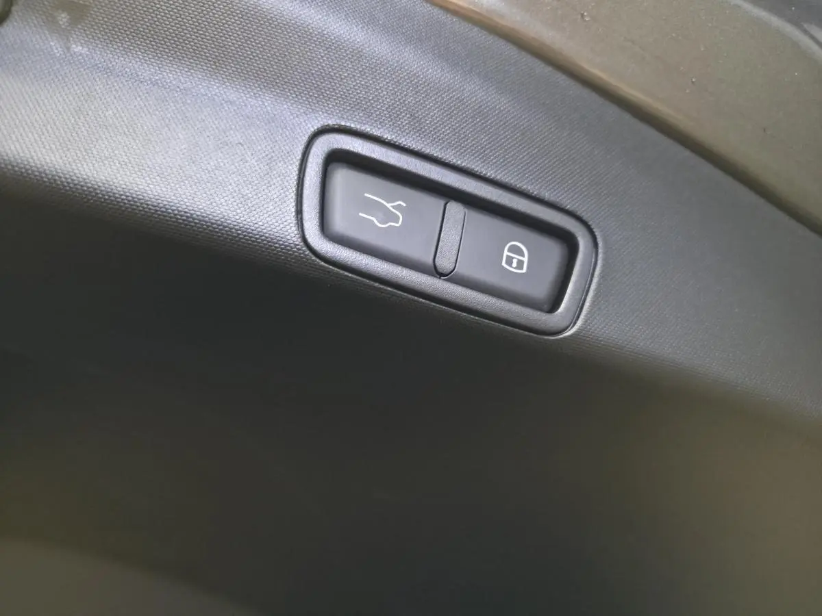 Boutons d'ouverture et de verrouillage du hayon électrique sur le coffre d'un Alfa Romeo Stelvio gris.