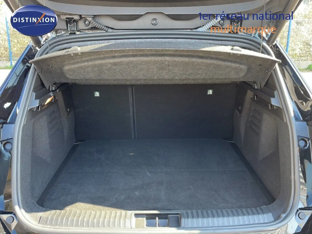 Coffre ouvert vu de l'arrière d'une Renault Symbioz noire étoile métal, montrant un espace de chargement vide et spacieux.