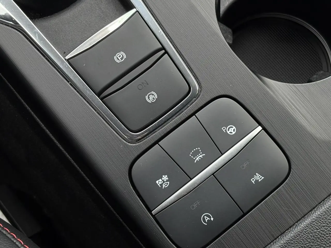 Gros plan sur la console centrale noire du Ford Kuga 2023 avec boutons de contrôle électronique et finition ST-Line.