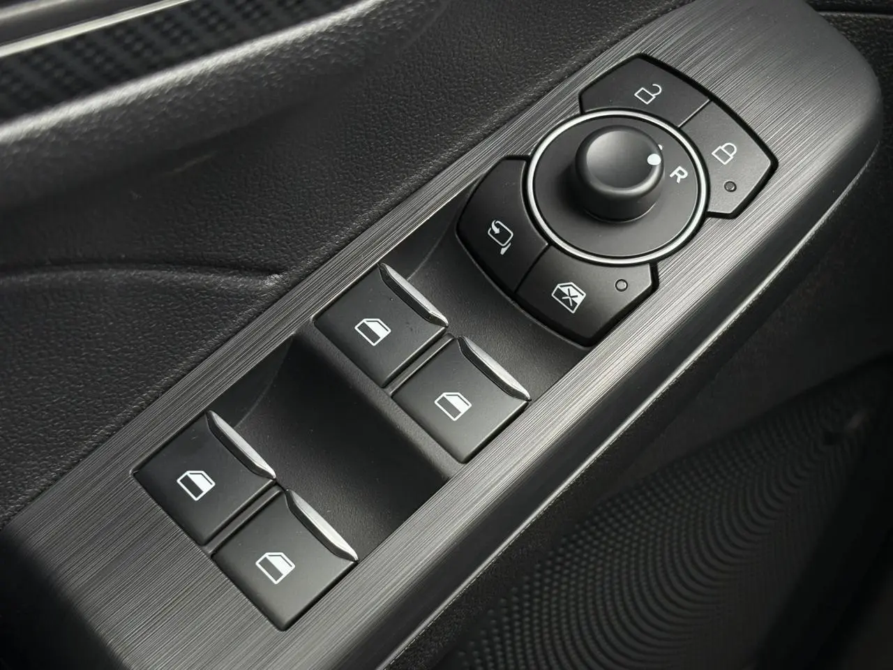 Gros plan sur les commandes de lève-vitres et rétroviseurs côté conducteur du Ford Kuga 2023, finition ST-Line.