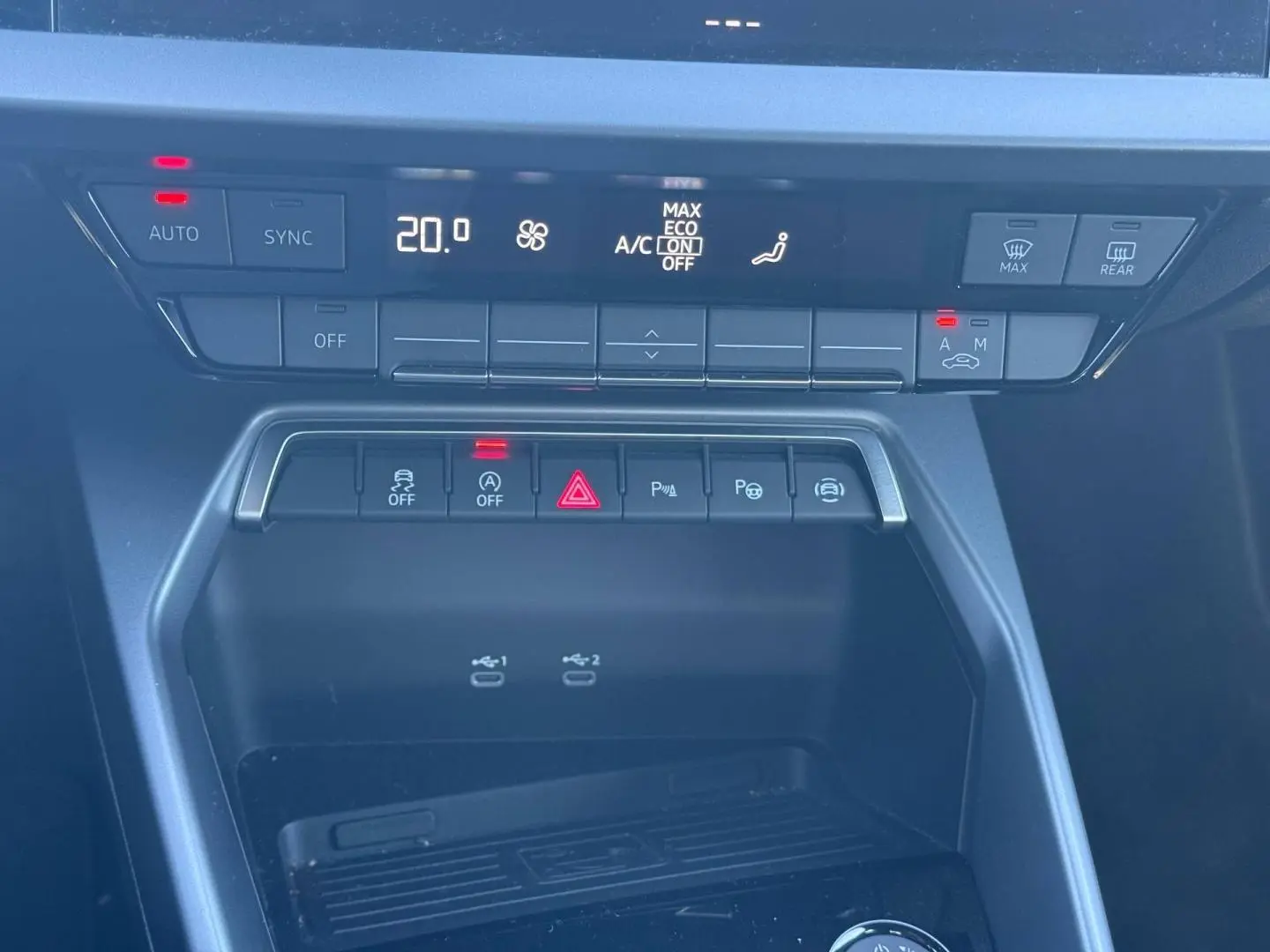 Vue rapprochée de la console centrale de l'Audi A3 Sportback 2024, avec commandes clim et ports USB visibles.