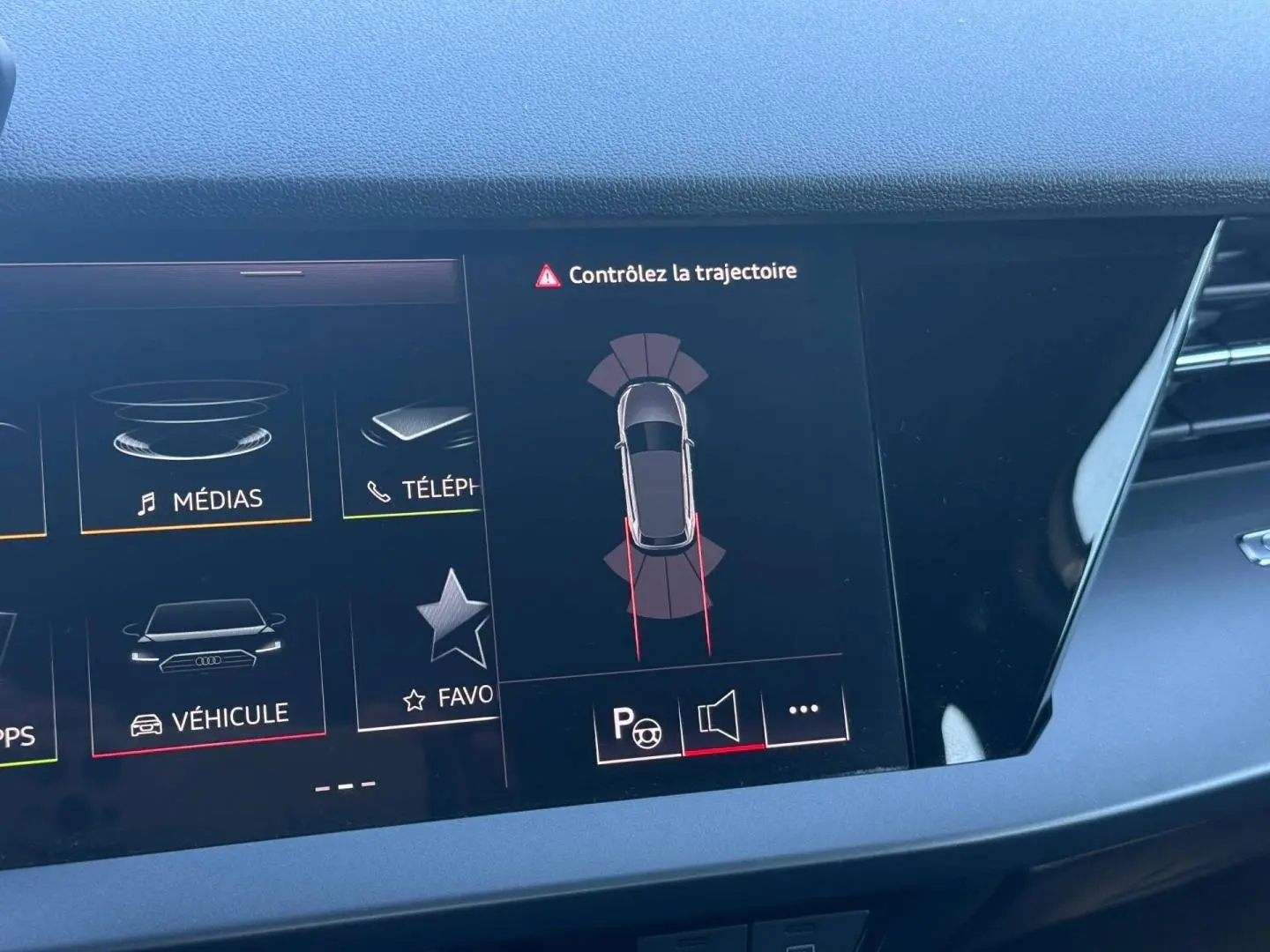Écran central de l'Audi A3 Sportback 2024 affichant l'alerte de trajectoire et le menu véhicule, intérieur noir.
