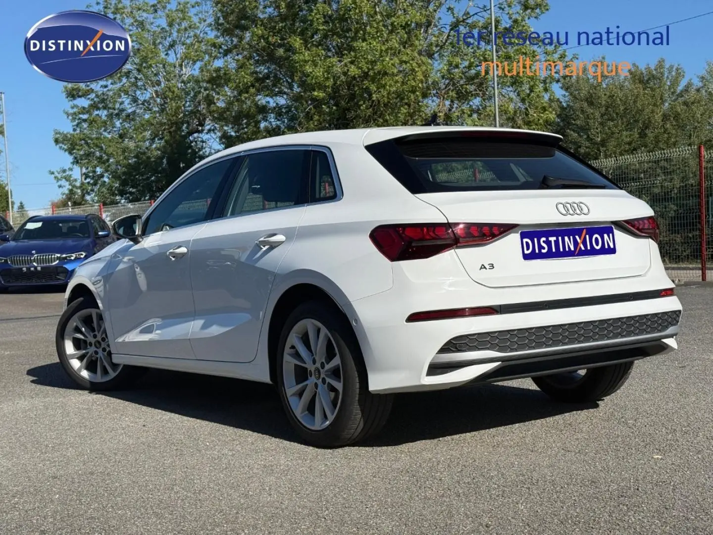 Audi A3 Sportback blanc Arkona vue 3/4 arrière droit, avec jantes alu et becquet noir distinctif.