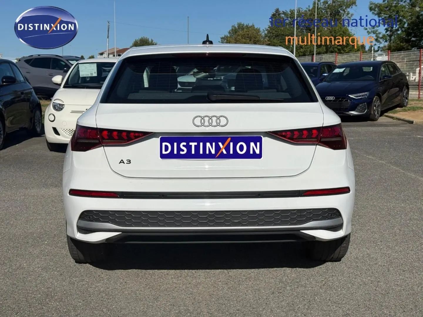 Vue arrière d'une Audi A3 Sportback blanche Arkona 2024 avec feux arrière LED et logo Audi visible.