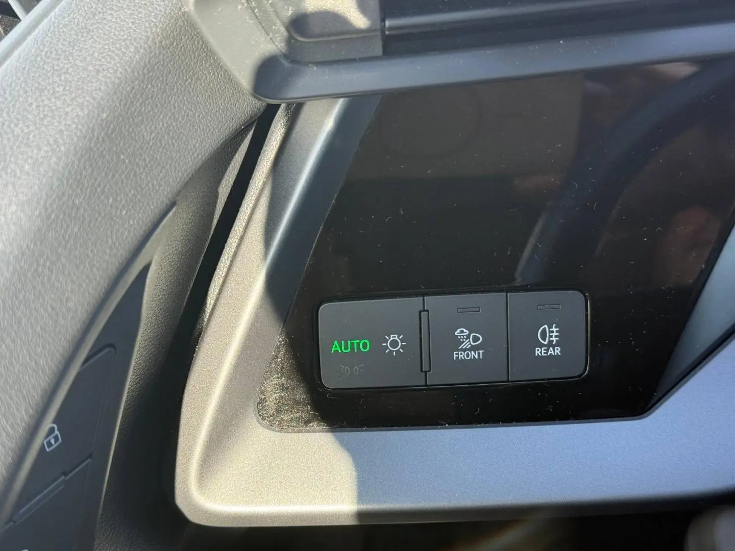 Gros plan sur les commandes d’éclairage à gauche du volant dans l’Audi A3 Sportback 2024, finition Design.