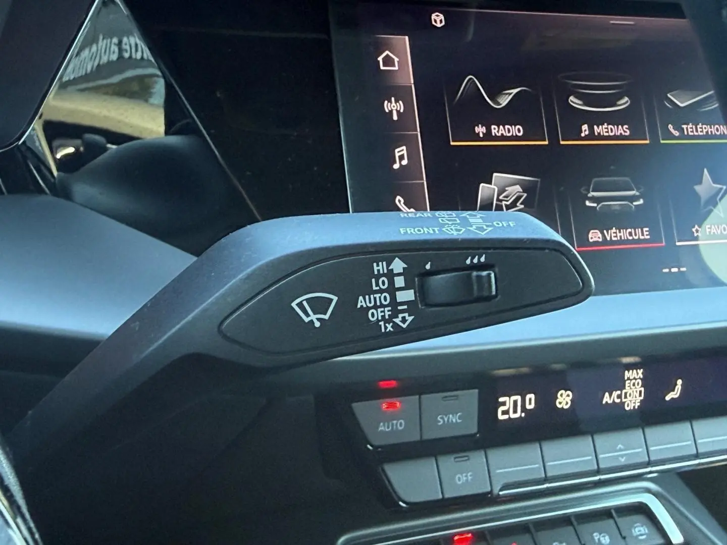 Gros plan sur la commande d’essuie-glace et l’écran tactile du tableau de bord de l’Audi A3 Sportback 2024.