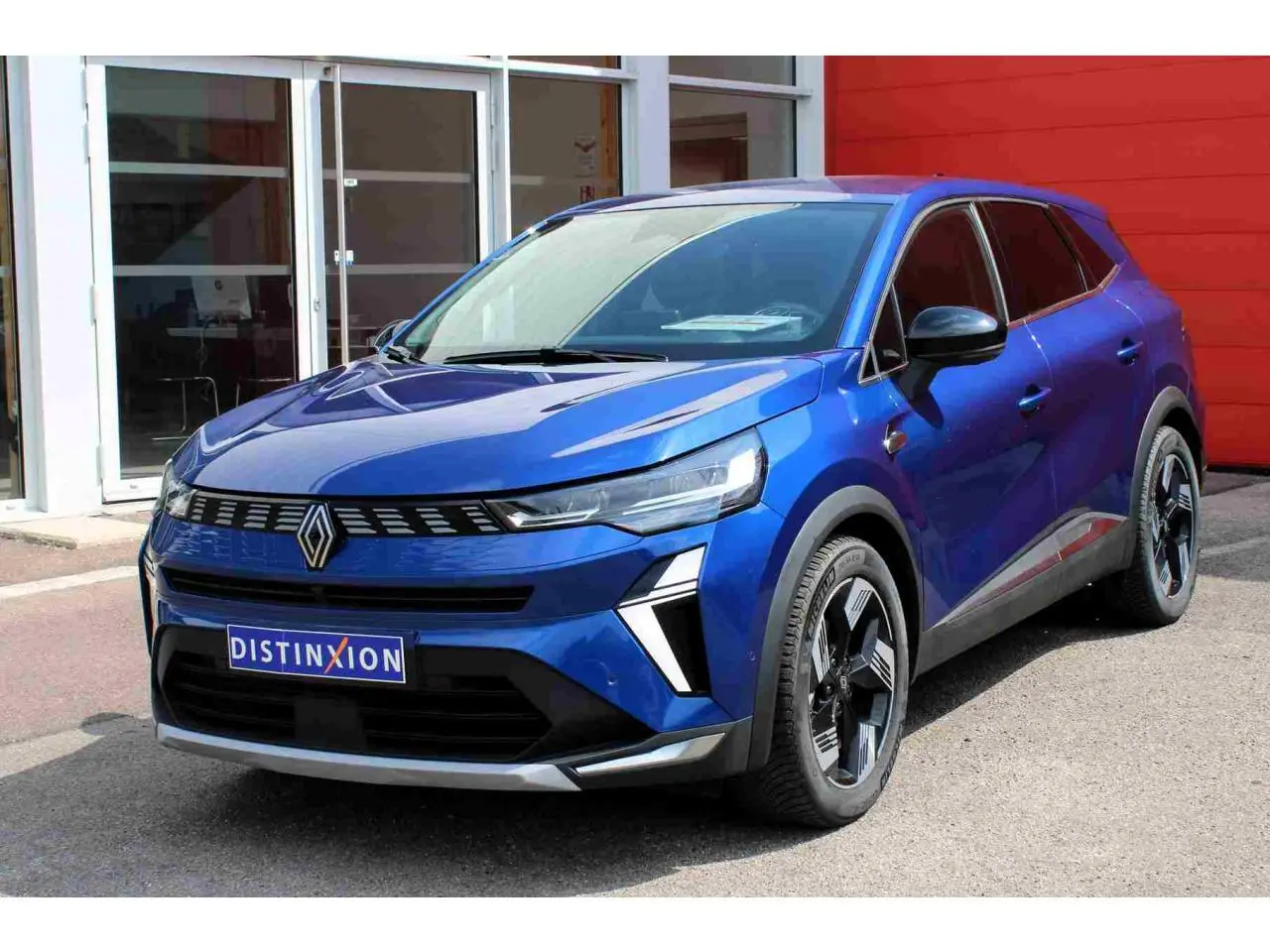 Renault Symbioz bleu 3/4 avant droit, calandre noire avec logo central et jantes alliage 19 pouces design moderne.