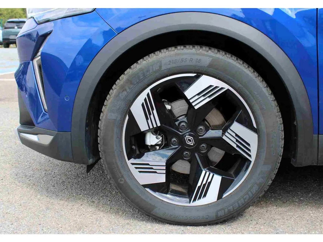 Gros plan sur la roue avant droite du Renault Symbioz bleu, avec jante alliage 19 pouces au design noir et argent.
